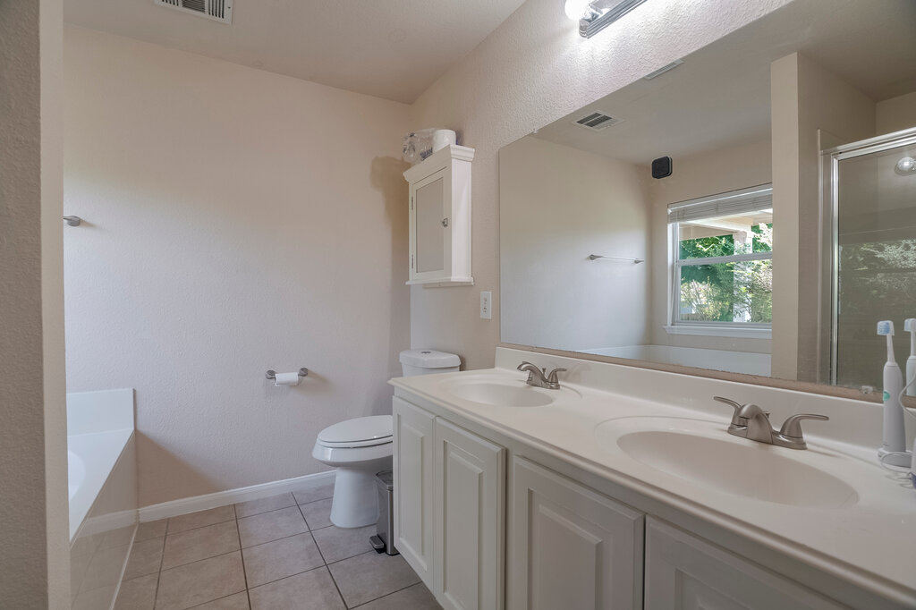 2724 Kickapoo Cavern Drive Pflugerville, TX 78660 - Photo 16 of 24 Double vanity, large mirror, and tiled floors create a functional and pleasant bathroom space.