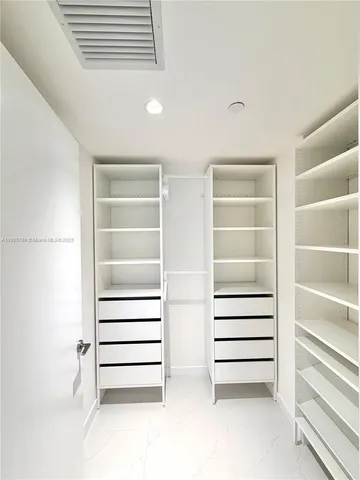 a view of walk in closet and empty room
