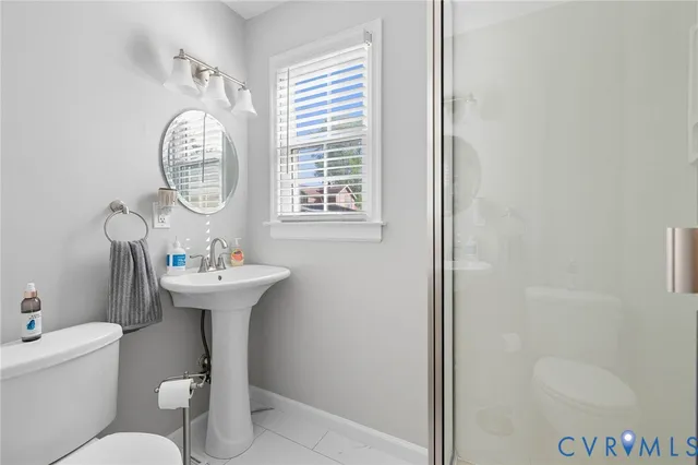 a bathroom with a toilet a sink and mirror
