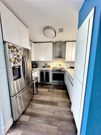 a kitchen with white cabinets and stainless steel appliances