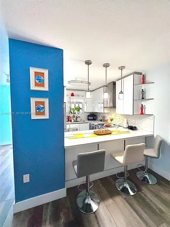 a view of a kitchen with a dining table and chairs