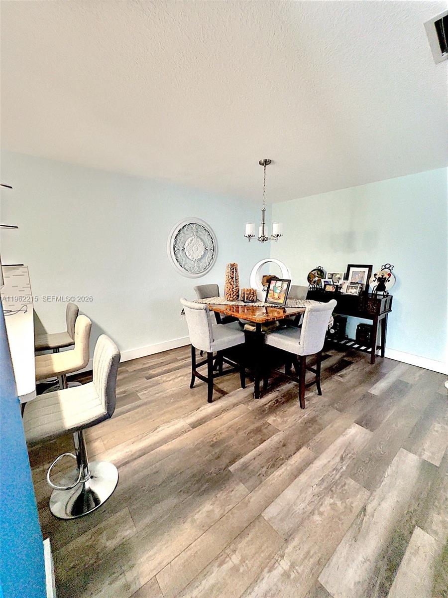 6761 Northwest 182nd Street, Unit 103 Hialeah, FL 33015 - Photo 6 of 13 a living room with furniture a rug and a table