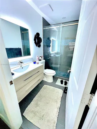 a bathroom with a double vanity sink toilet and mirror