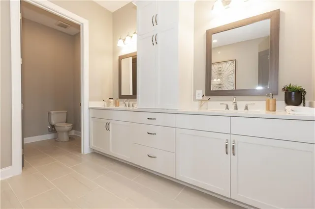 a bathroom with a double vanity sink mirror and toilet