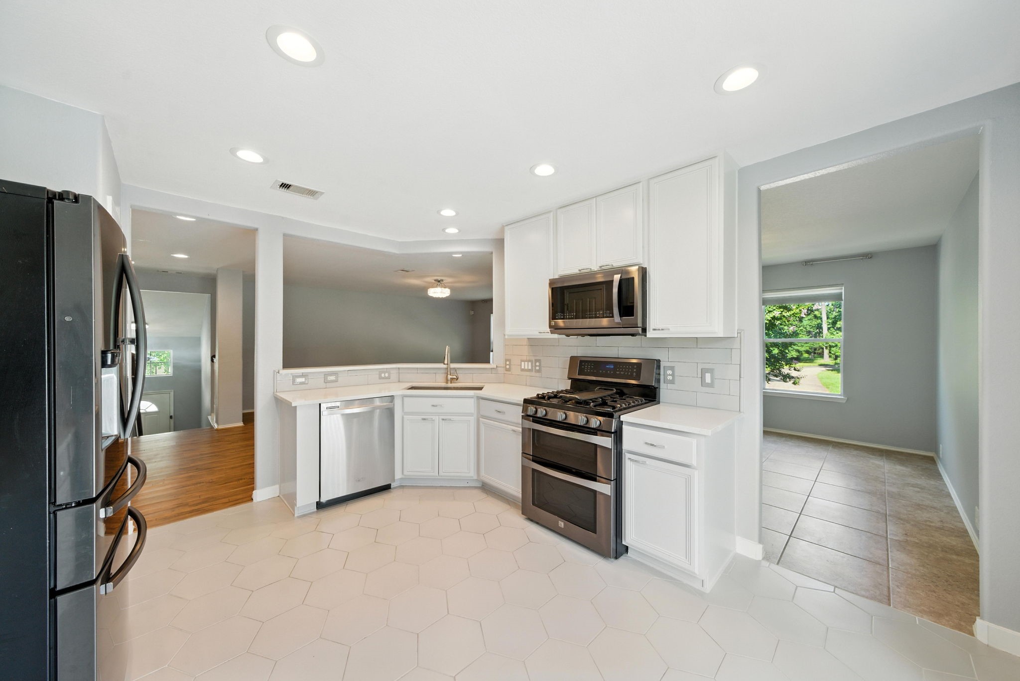 13600 Breton Ridge Street, Unit 7B Houston, TX 77070 - Photo 9 of 23 a large white kitchen with a sink stainless steel appliances and cabinets