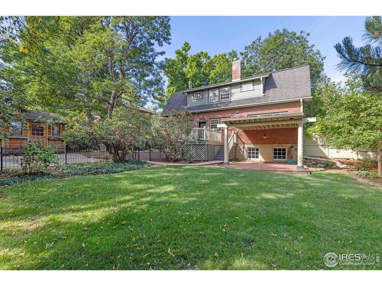 1064 10th Street Boulder, CO 80302 - Photo 27 of 40 a view of a big house with a big yard and large tree