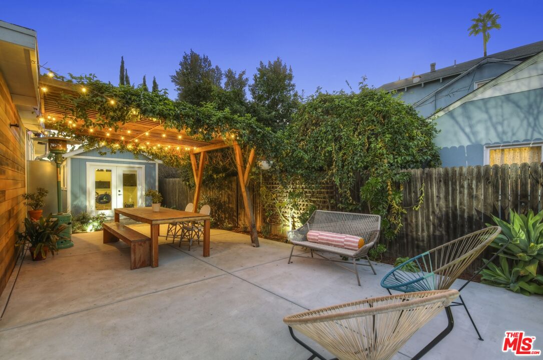114 Hackett Place Los Angeles, CA 90042 - Photo 30 of 30 a view of a patio with couches table and chairs with potted plants and a floor to ceiling window