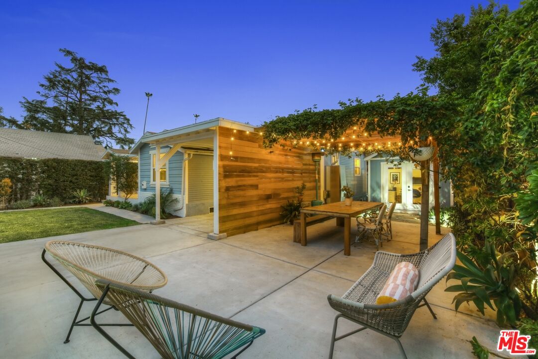 114 Hackett Place Los Angeles, CA 90042 - Photo 4 of 30 a view of a patio with couches table and chairs under an umbrella with palm trees