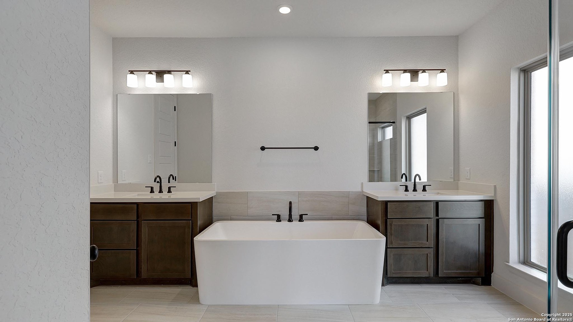 233 Hidalgo Boerne, TX 78006 - Photo 18 of 32 a spacious bathroom with a bathtub a sink and a mirror