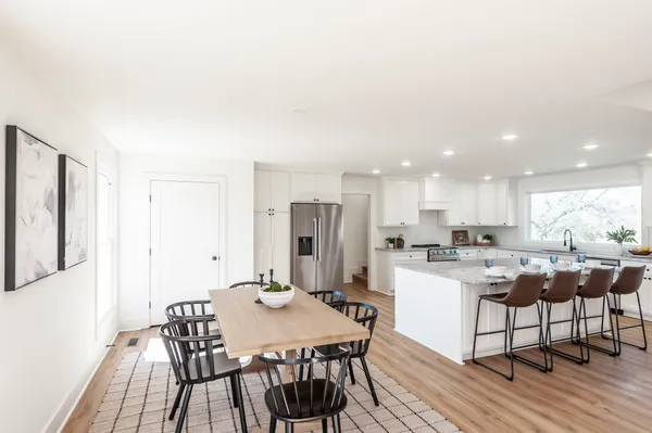 a large kitchen with stainless steel appliances granite countertop a lot of counter space and wooden floors