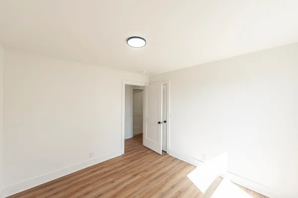 a view of an empty room with wooden floor