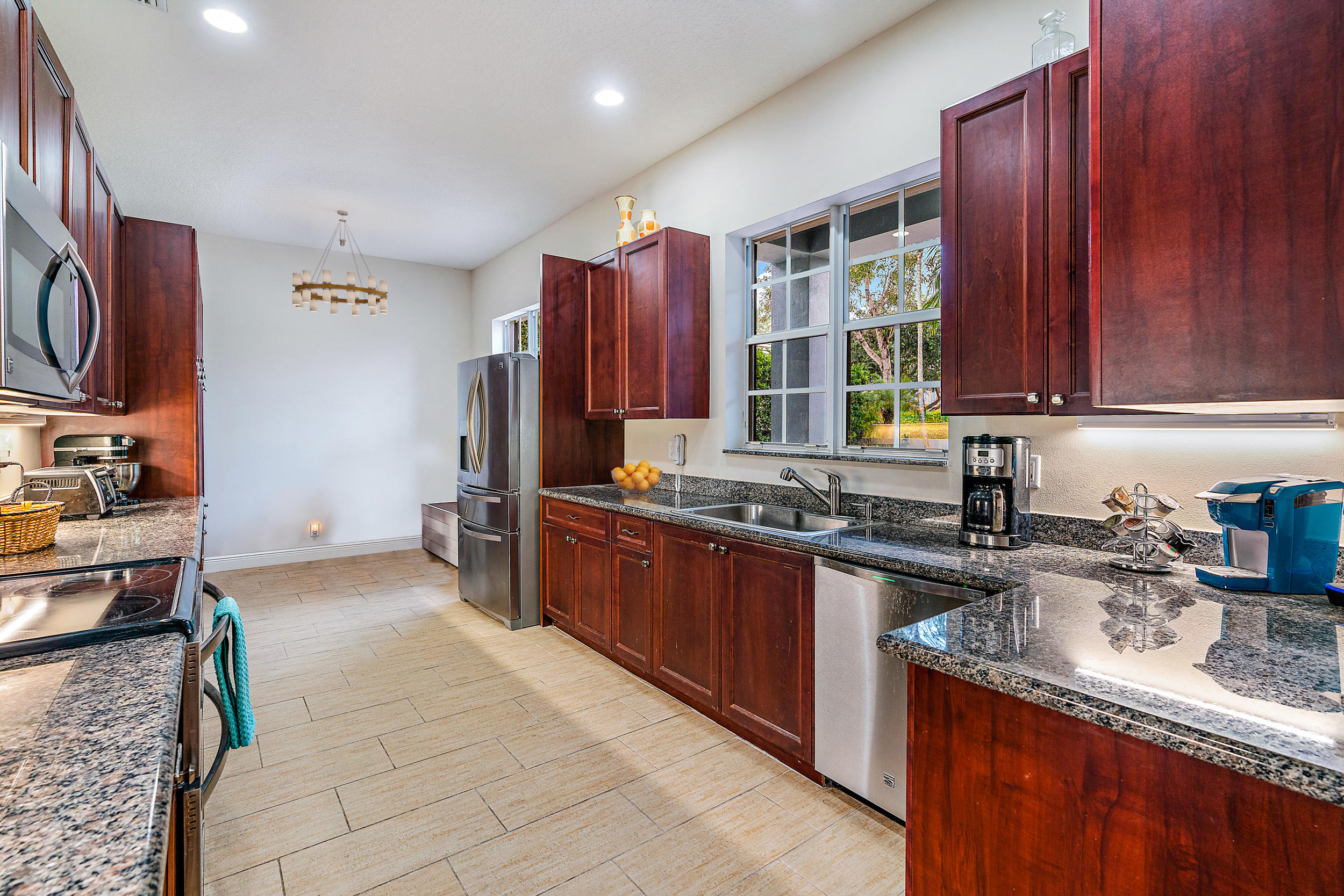 202 Botanica Drive Jupiter, FL 33458 - Photo 14 of 39 a kitchen with stainless steel appliances granite countertop a sink stove and refrigerator