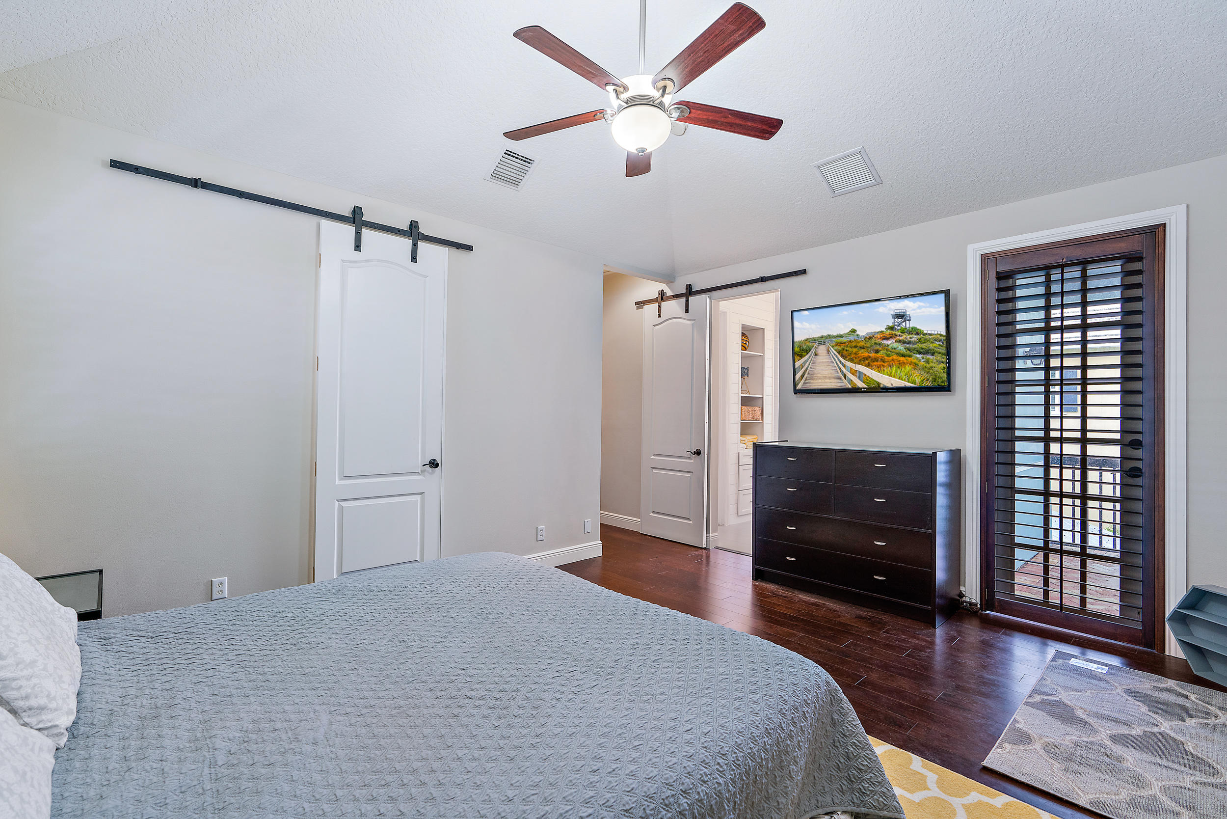 202 Botanica Drive Jupiter, FL 33458 - Photo 16 of 39 a bedroom with a bed and wooden floor