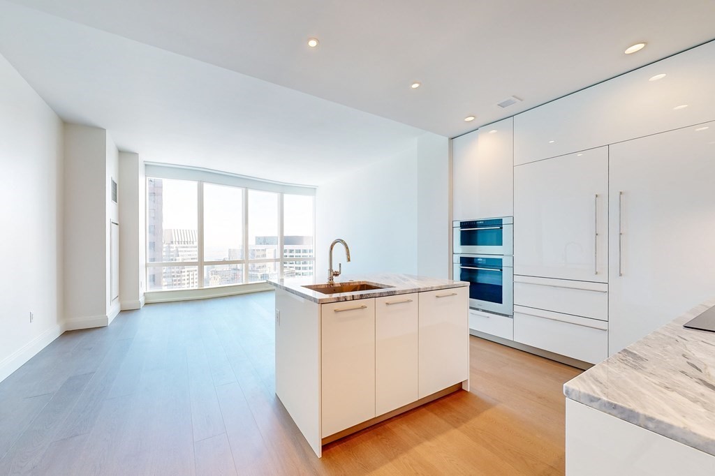 240 Devonshire Street, Unit 3911 Boston, MA 02110 - Photo 2 of 40 a kitchen with stainless steel appliances granite countertop a stove and a refrigerator