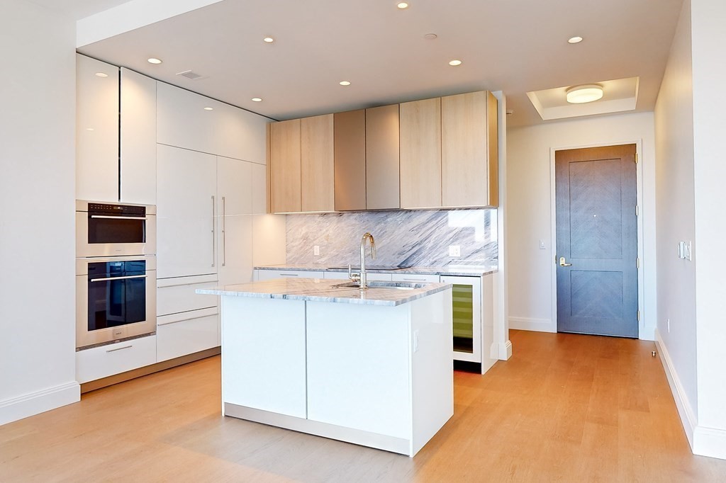 240 Devonshire Street, Unit 3911 Boston, MA 02110 - Photo 3 of 40 a kitchen with stainless steel appliances granite countertop a stove a sink and a refrigerator