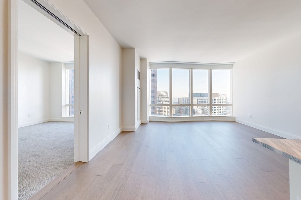 240 Devonshire Street, Unit 3911 Boston, MA 02110 - Photo 4 of 40 an empty room with wooden floor and windows