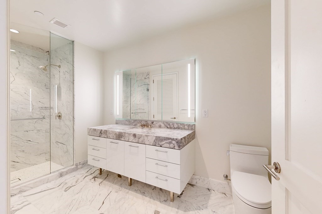 240 Devonshire Street, Unit 3911 Boston, MA 02110 - Photo 6 of 40 a bathroom with a granite countertop sink mirror vanity and toilet