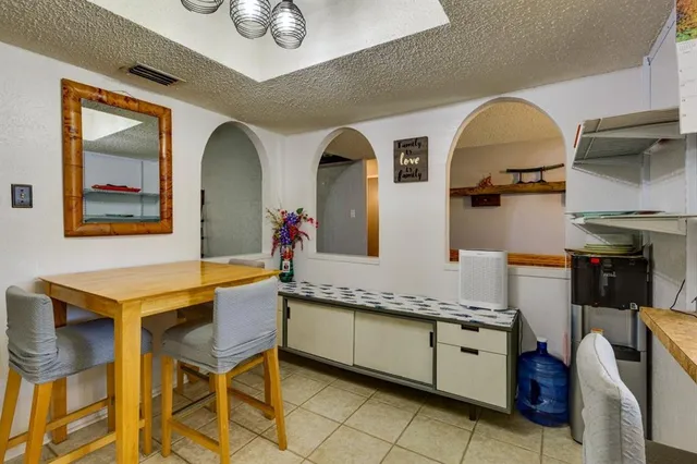 a kitchen with stainless steel appliances granite countertop a stove a sink and a dining table