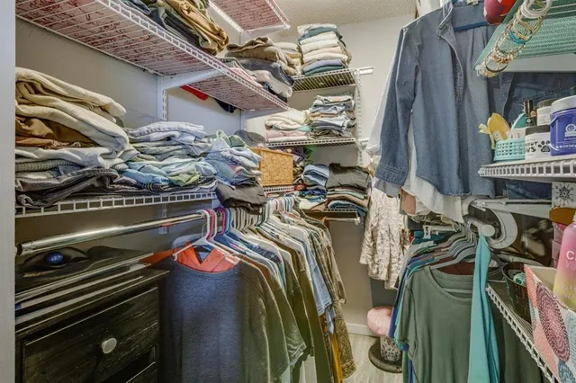 a view of walk in closet with clothes and shoes