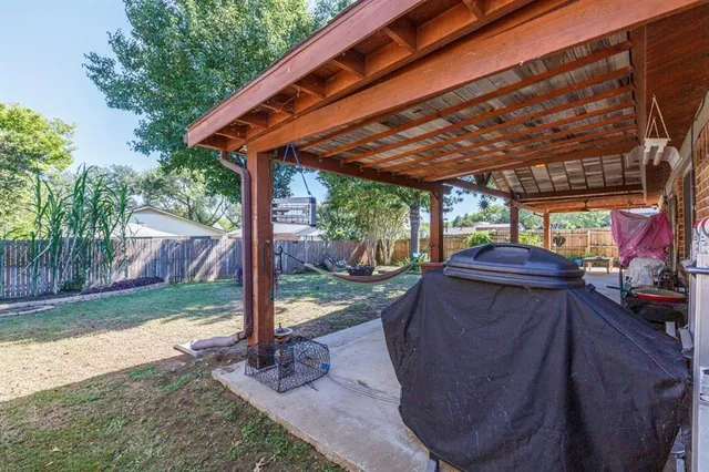 a patio with a table and chairs and potted plants