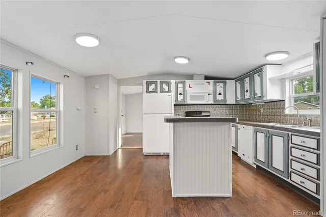 a kitchen with granite countertop a refrigerator and a stove top oven