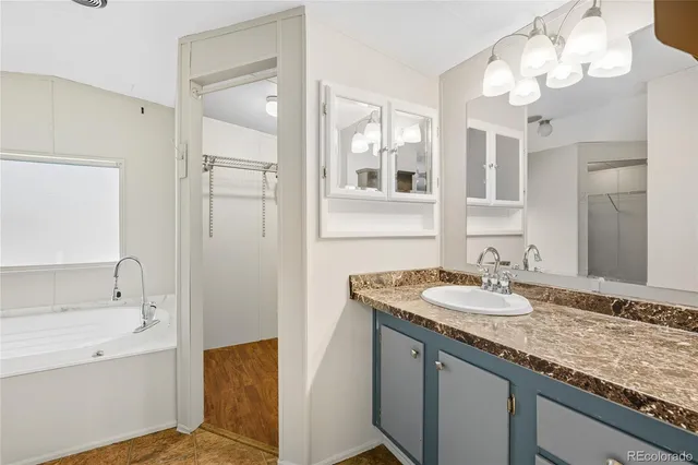 a bathroom with a granite countertop sink a large mirror and a shower