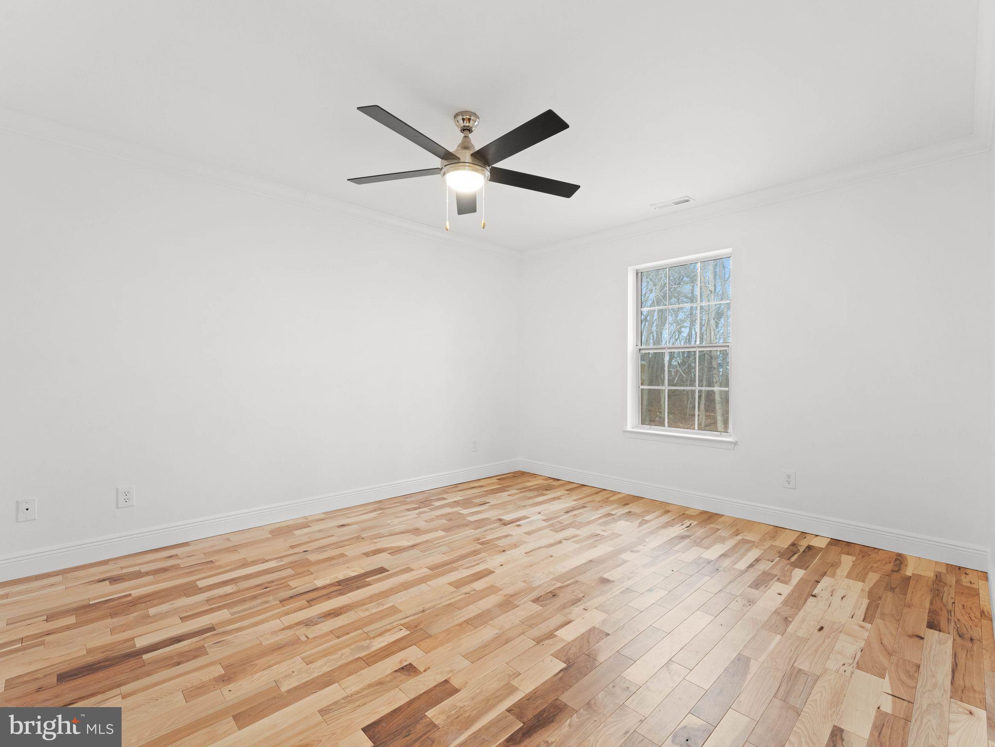 617 Caribbean Way Williamstown, NJ 08094 - Photo 12 of 26 a view of empty room with wooden floor and fan