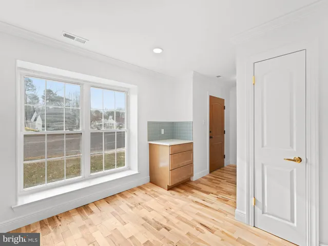 an empty room with a window and cabinet