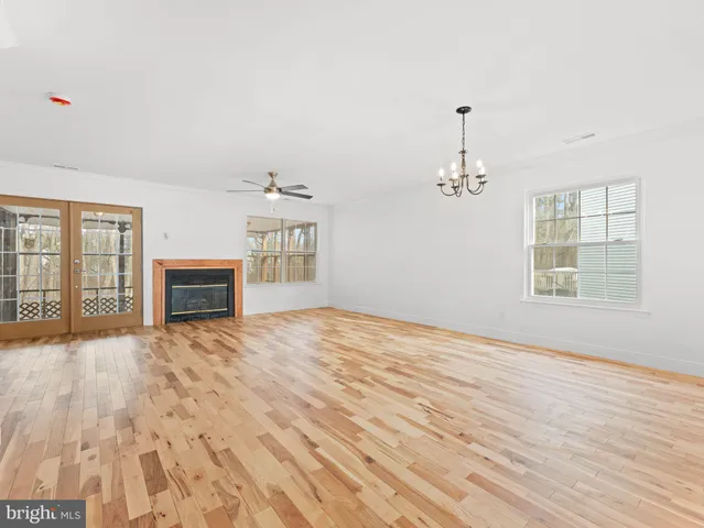 a view of empty room with wooden floor and fireplace