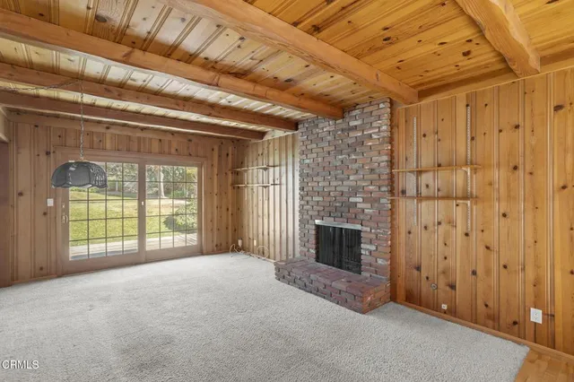 a view of an empty room with a fireplace and a window