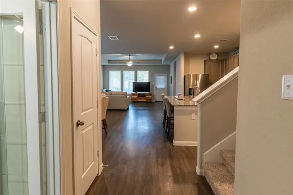 a view of a hallway with wooden floor and staircase