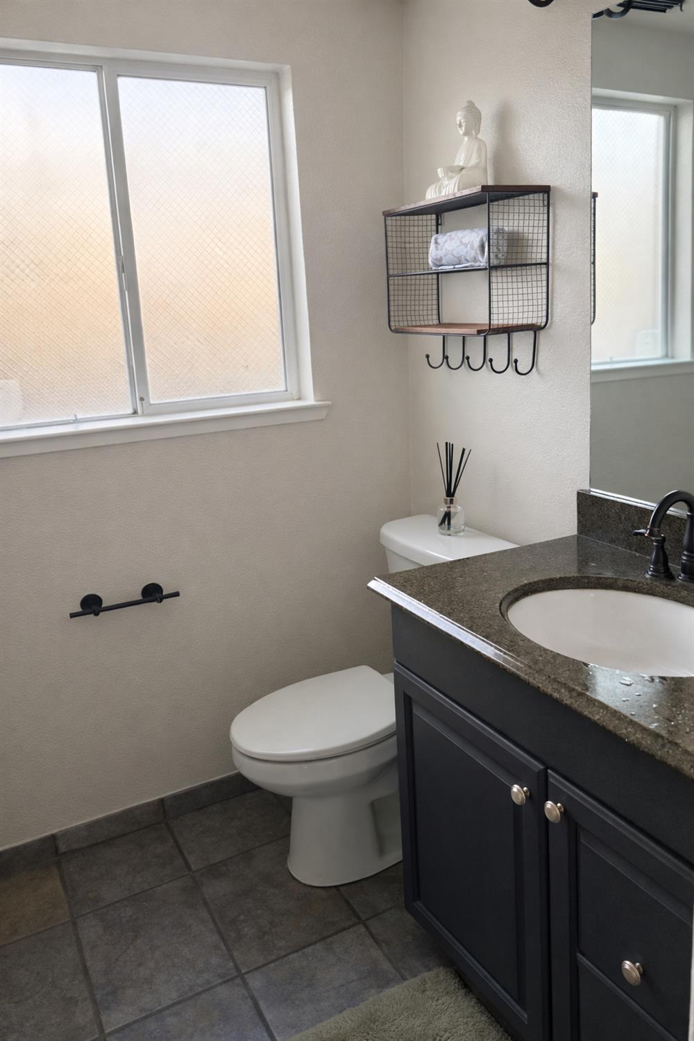4909 Hidden Meadow Way Antelope, CA 95843 - Photo 16 of 35 a bathroom with a granite countertop sink toilet and mirror