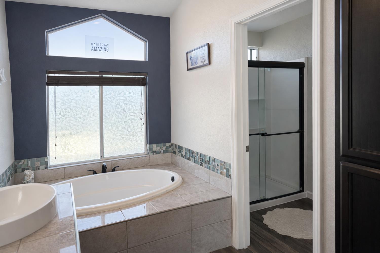 4909 Hidden Meadow Way Antelope, CA 95843 - Photo 29 of 35 a bathroom with a granite countertop tub and a sink