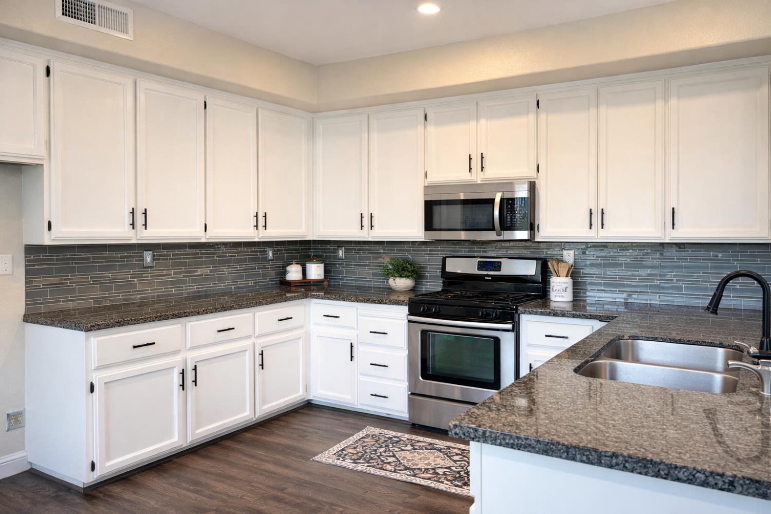 4909 Hidden Meadow Way Antelope, CA 95843 - Photo 10 of 35 a kitchen with granite countertop white cabinets and stainless steel appliances