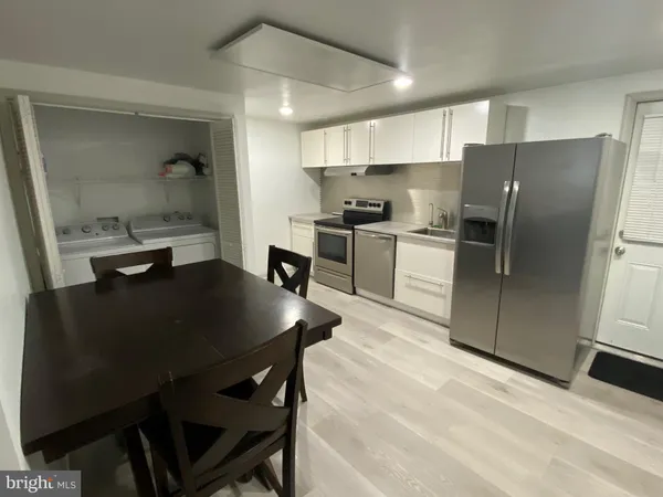 a kitchen with stainless steel appliances granite countertop a sink refrigerator and cabinets