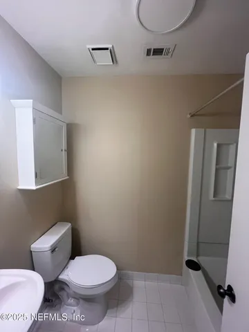 a bathroom with a toilet and a mirror