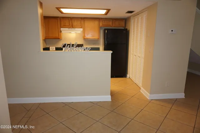 a utility room with cabinets and refrigerator