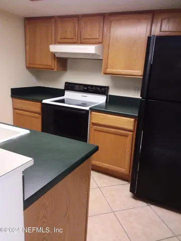 a kitchen with stainless steel appliances granite countertop a refrigerator a sink and dishwasher