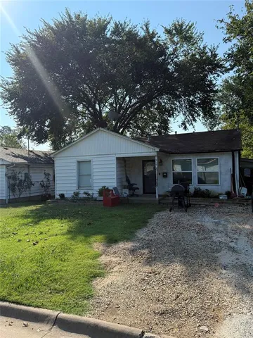 a view of a backyard with plants and large tree
