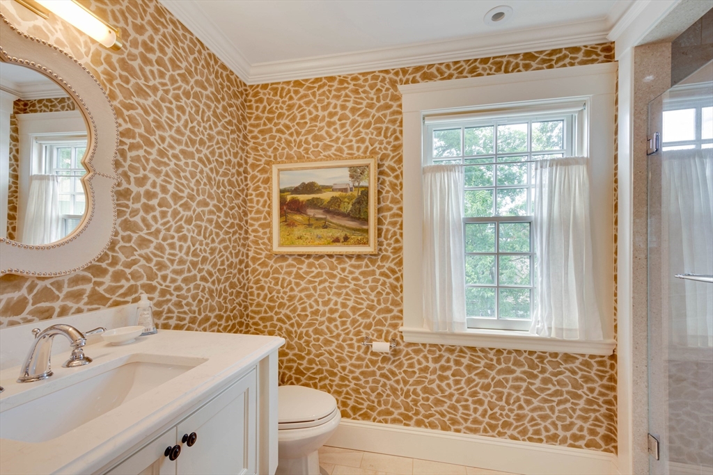 24 Cleveland Road Needham, MA 02492 - Photo 26 of 42 a bathroom with a toilet a sink a mirror and a window