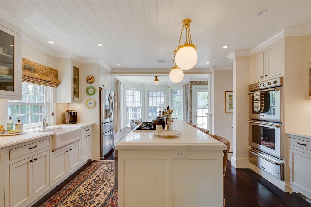 24 Cleveland Road Needham, MA 02492 - Photo 8 of 42 a kitchen with stainless steel appliances kitchen island granite countertop a stove and a sink