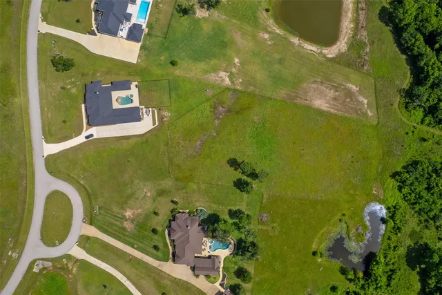 an aerial view of a residential houses with yard