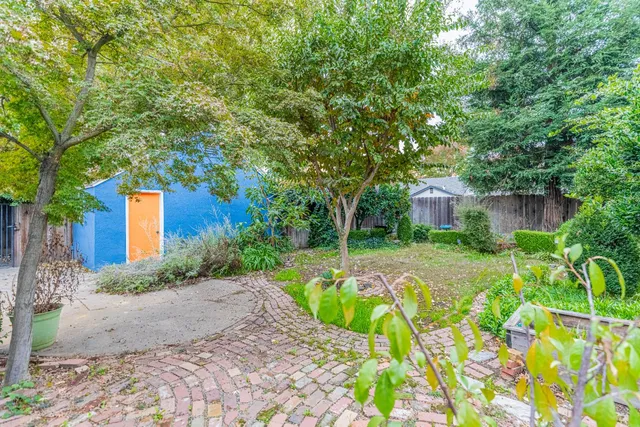 a front view of a house with a yard and potted plants