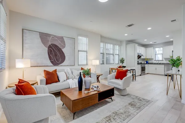 a living room with furniture kitchen view and a table
