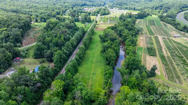 an aerial view of residential houses with outdoor space and trees