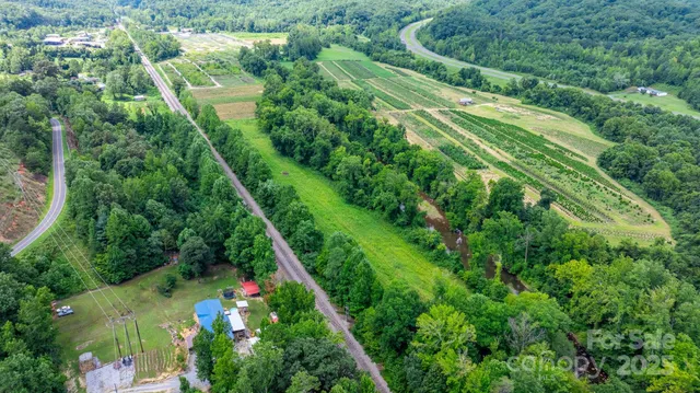 an aerial view of residential house with outdoor space and trees all around
