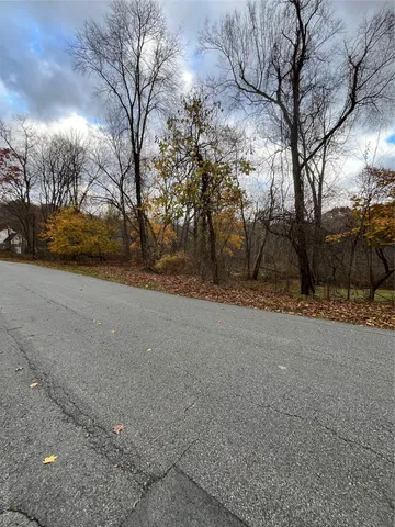 a view of a field with trees in the background