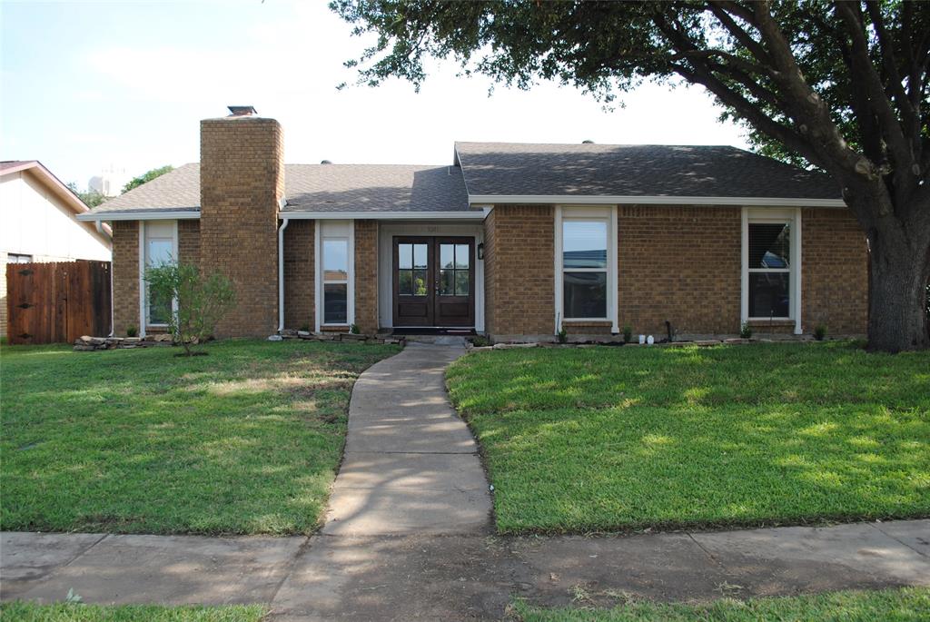 5241 Reed Drive The Colony, TX 75056 - Photo 1 of 26 Brick facade residence featuring a prominent brick chimney, dual pane windows, and a paved walkway leading to the entry