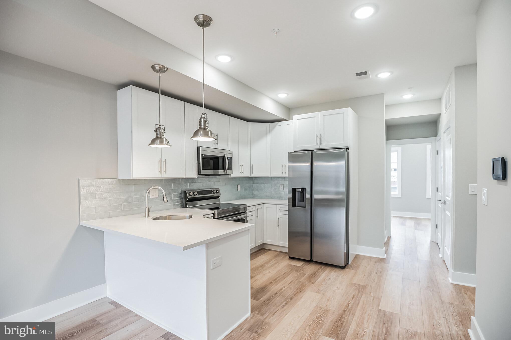 2216 Emerald Street, Unit B Philadelphia, PA 19125 - Photo 1 of 1 a kitchen with stainless steel appliances a refrigerator stove microwave and cabinets