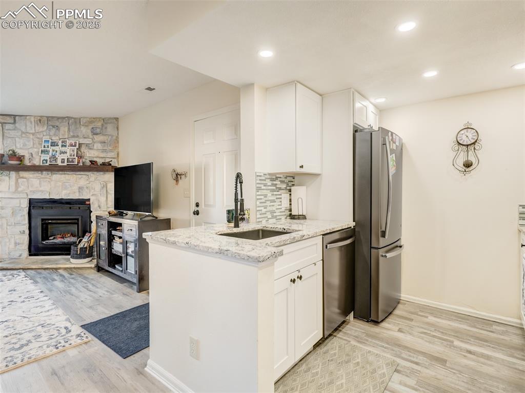 842 Tenderfoot Hill Road, Unit 1 Colorado Springs, CO 80906 - Photo 19 of 41 a kitchen with stainless steel appliances a stove refrigerator sink and a fireplace